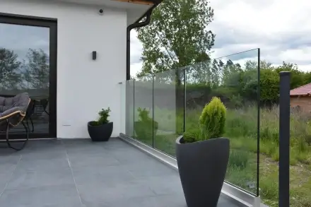 Sklenené zábradlie na terase presvetlenej denným svetlom - čistý výhľad do záhrady