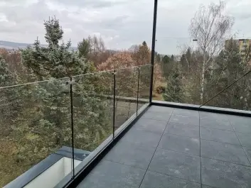 Detail montáže skleneného zábradlia v hliníkovom profile antracit na terase novostavby